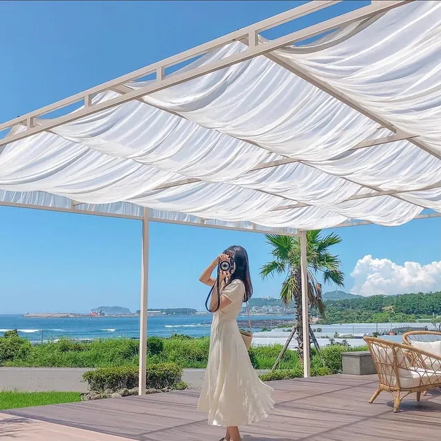 Taking photos under the sail shade on a terrace facing the sea