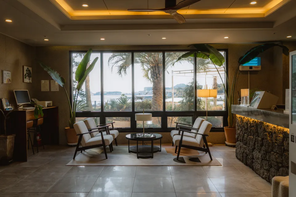 The Hotel Seogwipean lobby with sofas and tall windows