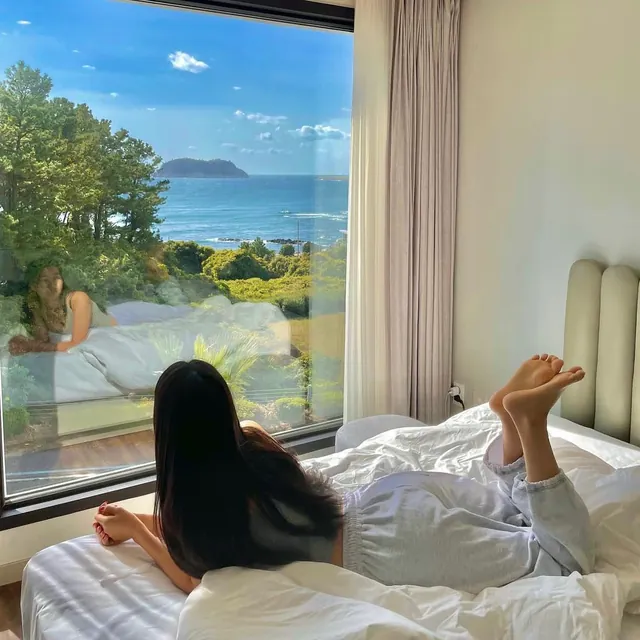 Lying on the bed and gazing at the sea and an island through the window