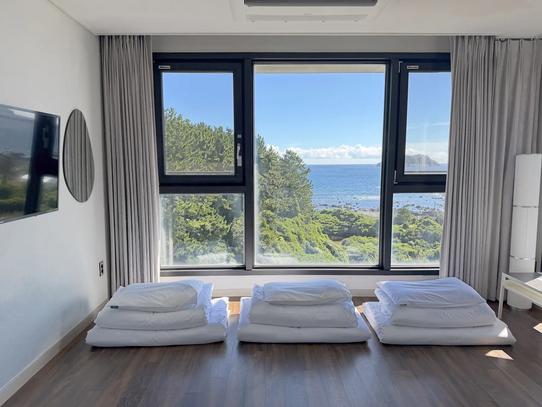 Ondol room at Hotel Seogwipean with floor-style bedding and an ocean view